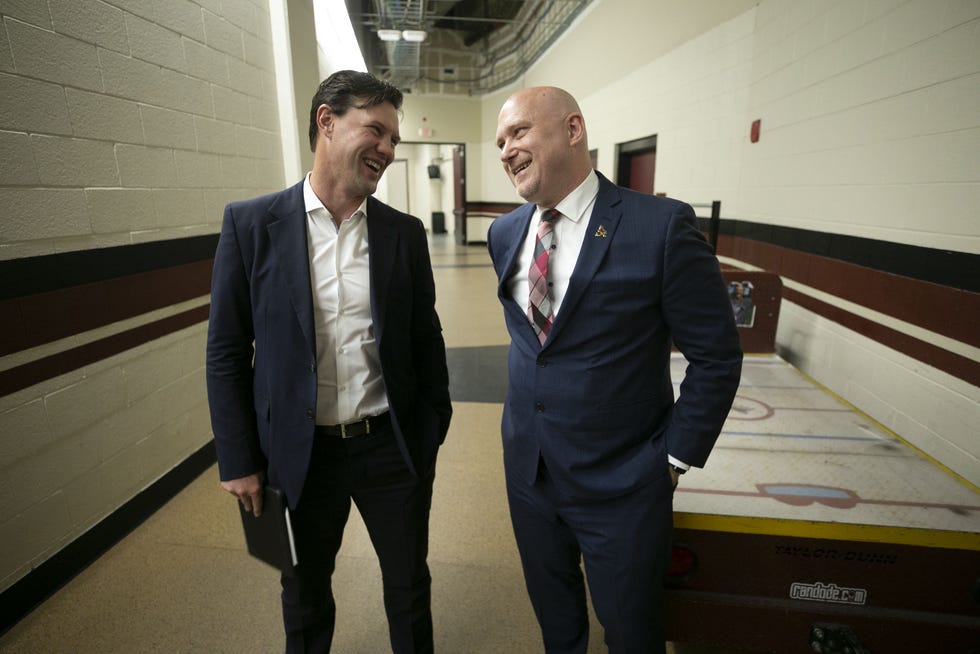 New Coyotes head coach Andre Tourigny, right, is congratulated by Shane Doan, former Coyotes player and now the team's chief hockey development officer, following an introductory press conference at Gila River Arena in Glendale on July 1, 2021.